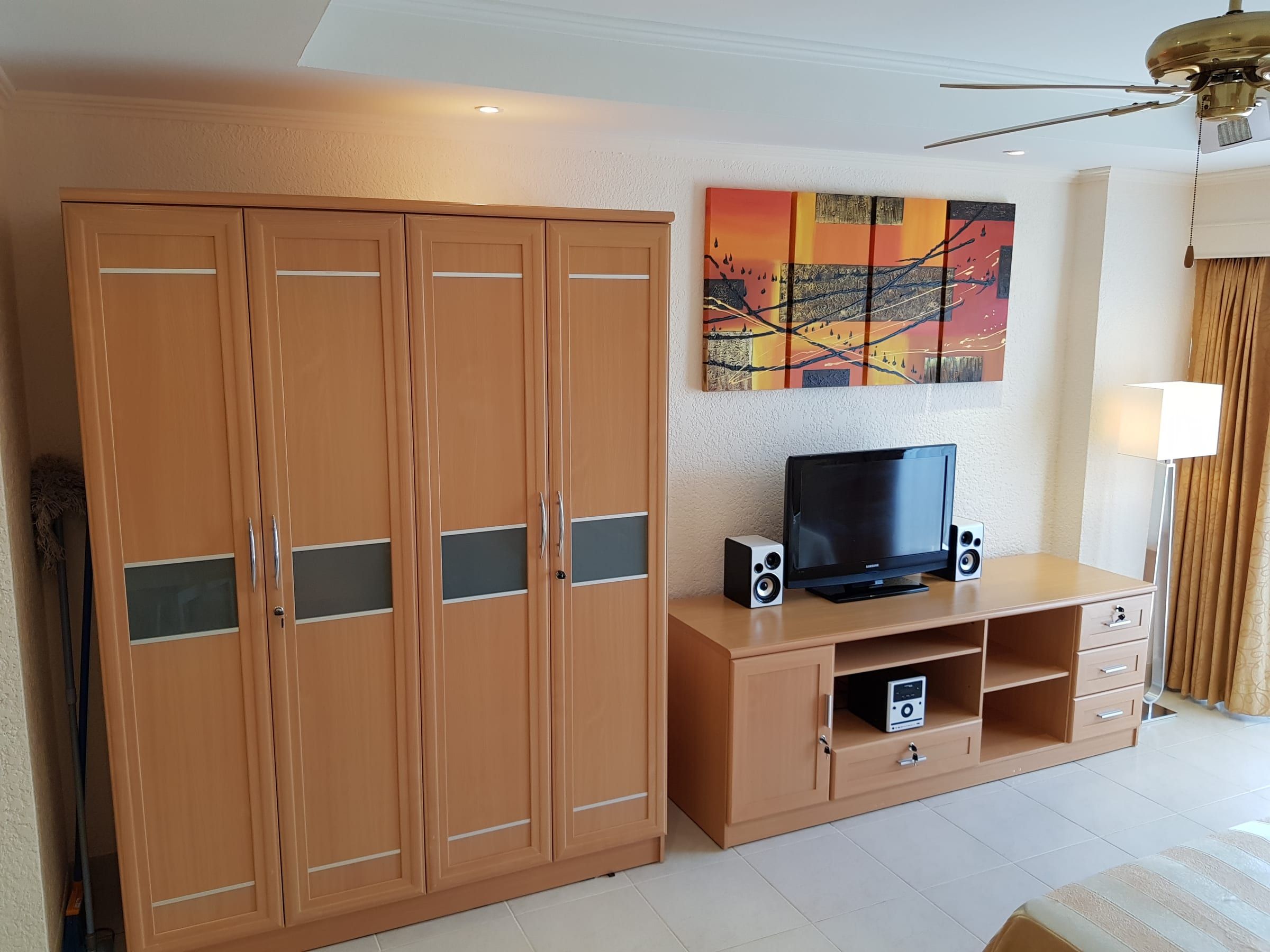 Studio Typ A: heller Kleiderschrank, Flachbild-TV auf dem Sideboard und ein Bild an der Wand