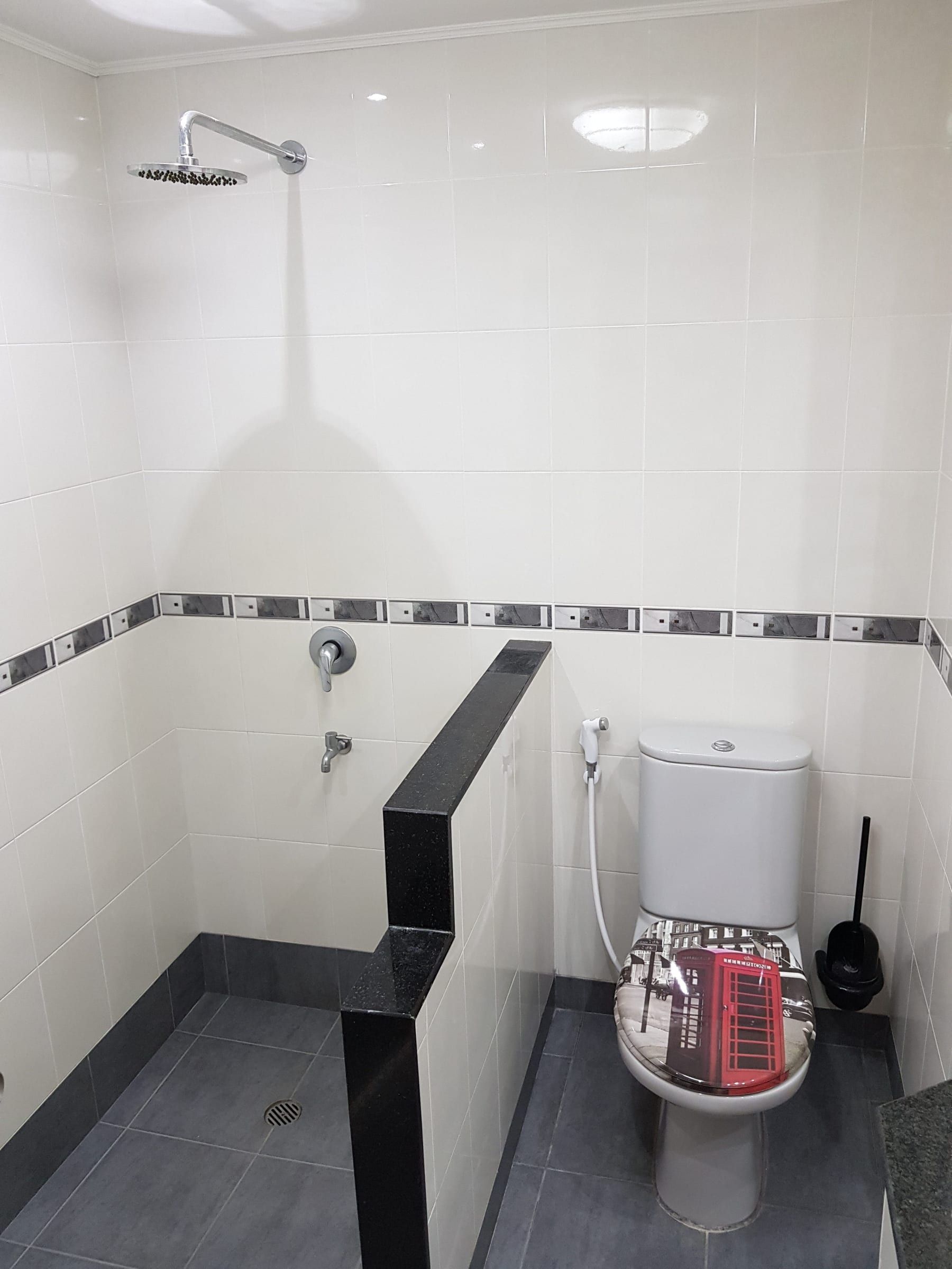 Badezimmer Typ A: gefliester Duschbereich mit Regendusche und WC