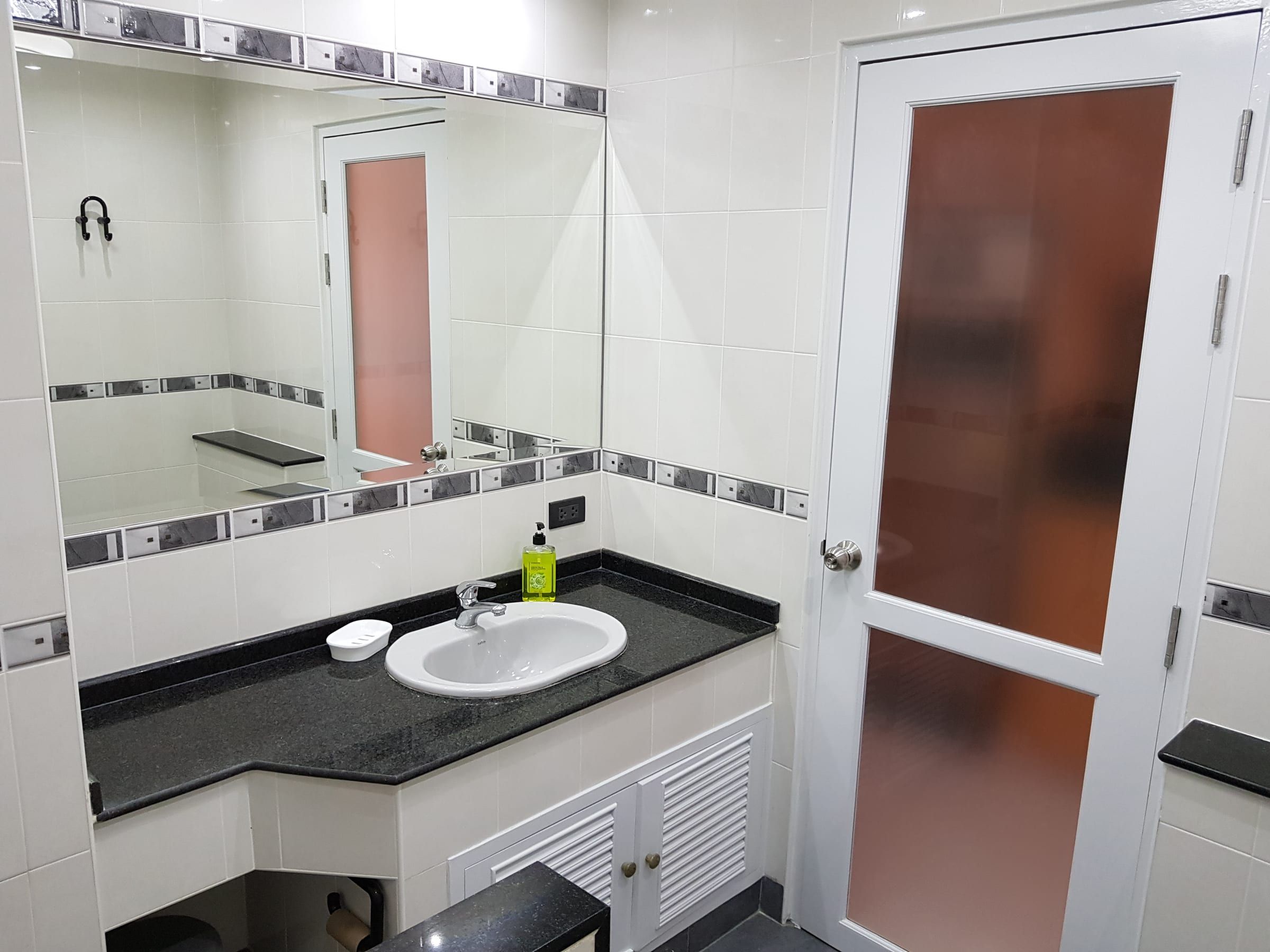Badezimmer Typ A: Waschbecken auf dunklem Granit-Waschtisch, großer Spiegel und Milchglastür