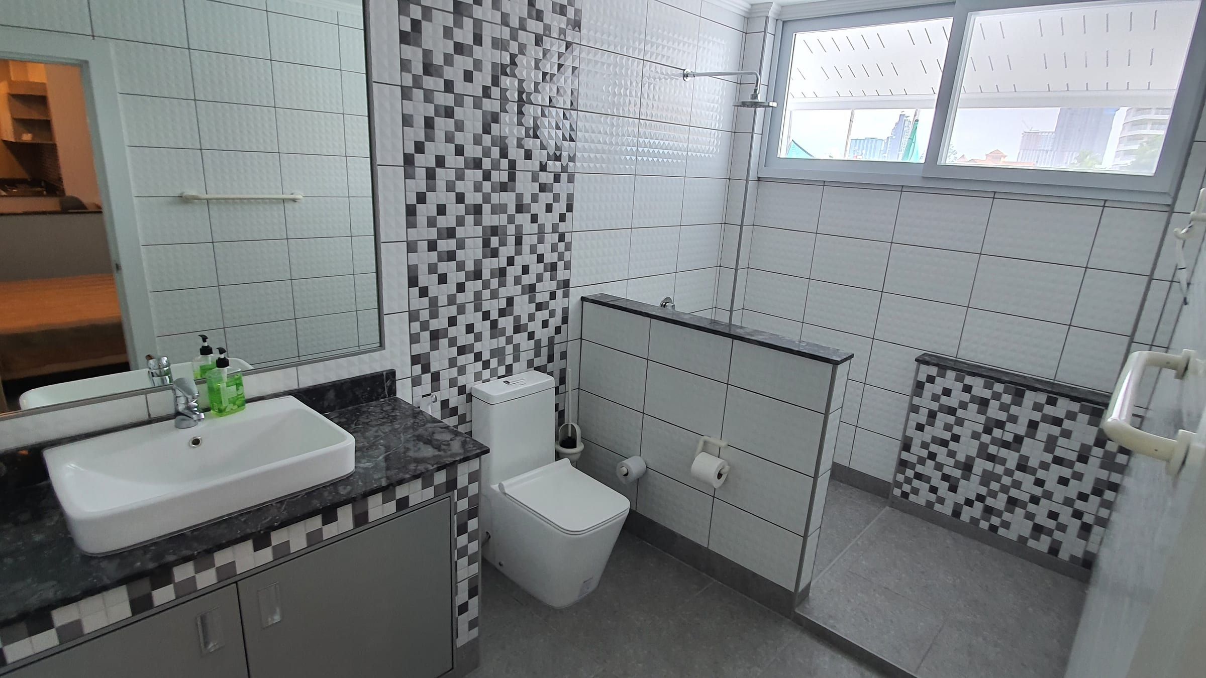 Salle de bains avec vasque blanche, WC et mosaïque noire et blanche