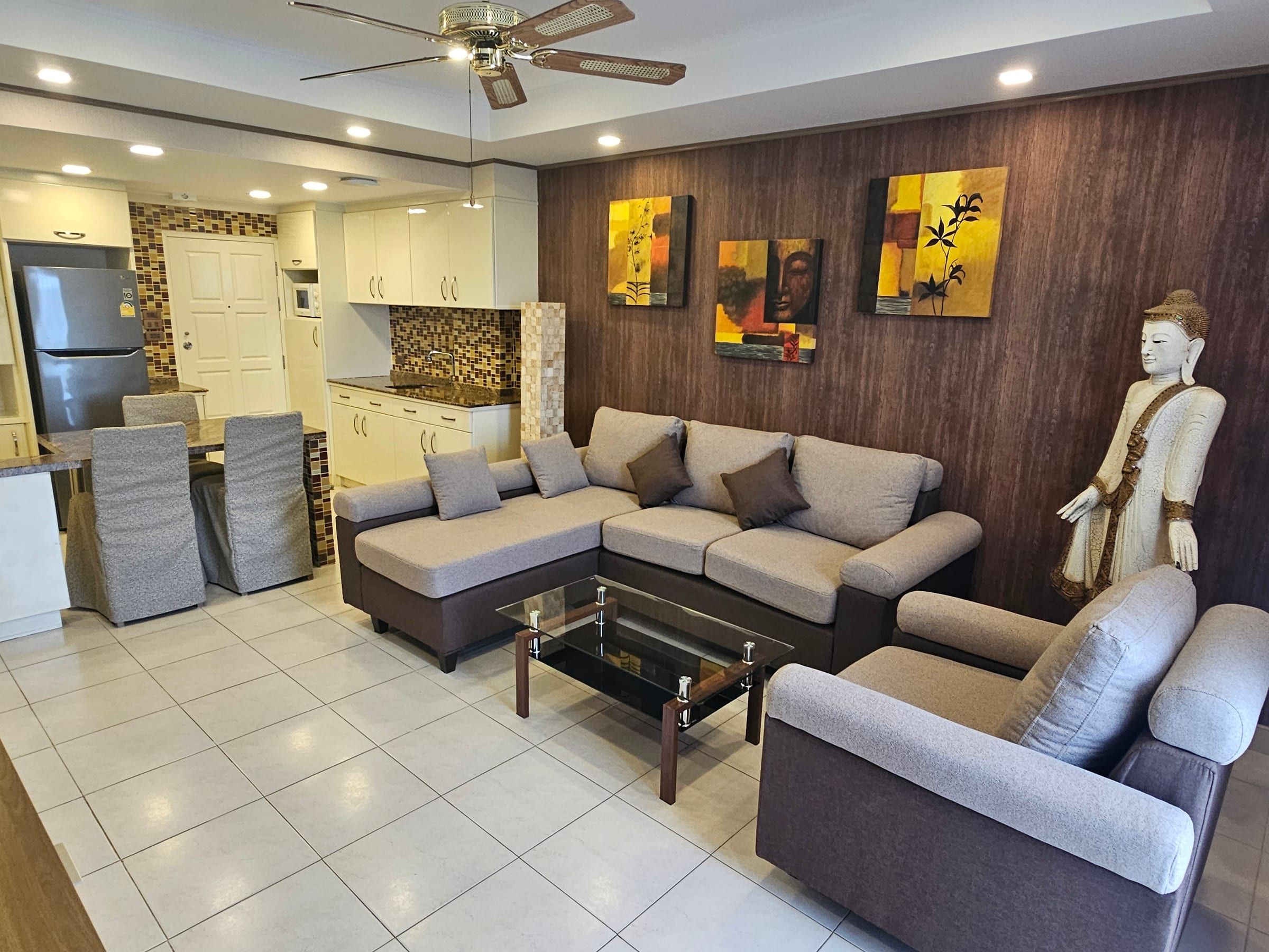 Living room with corner sofa and a view into the open kitchen with dining area