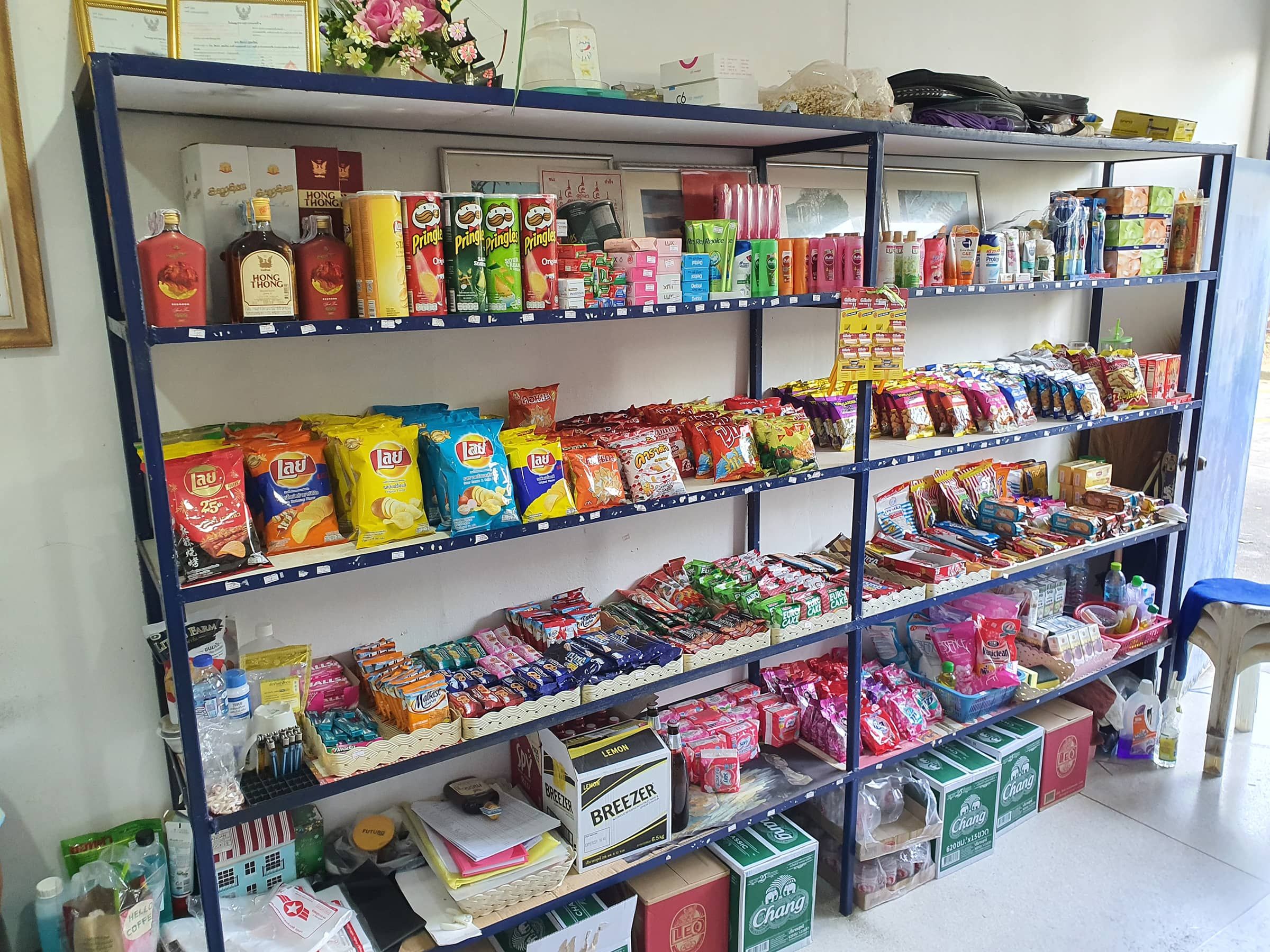 Regale des Mini Shops mit Chips, Snacks und verpackten Lebensmitteln