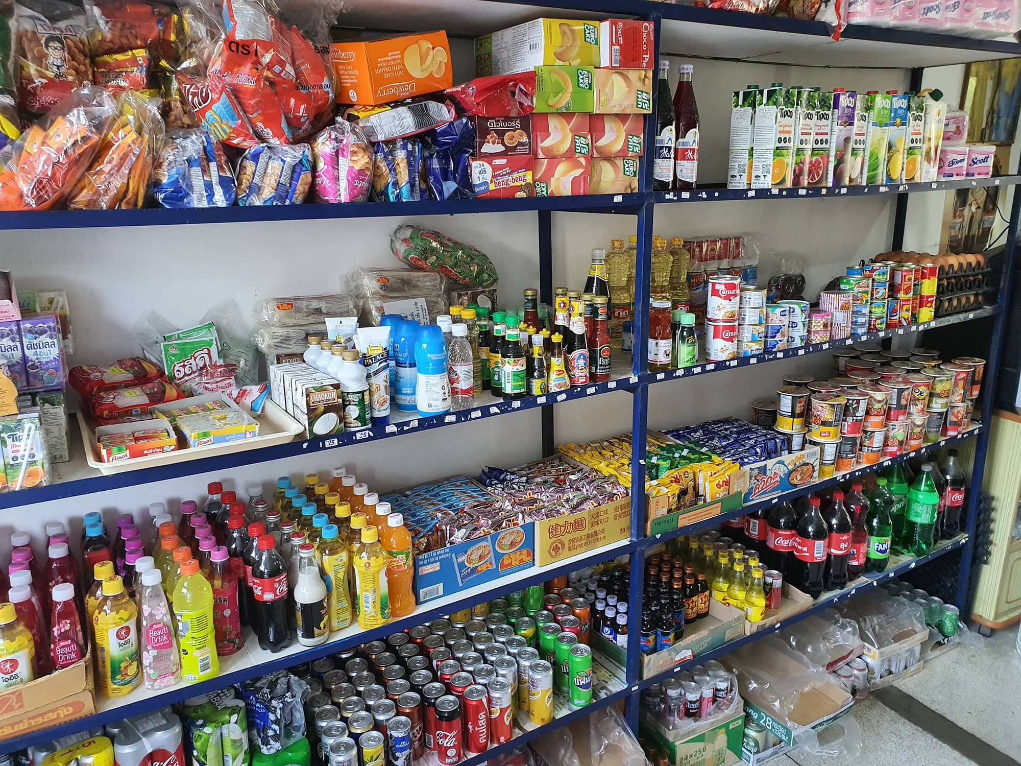 Schappen met dranken, sauzen, conserven en flessen in de mini shop